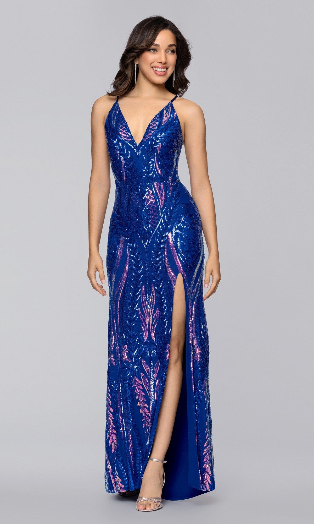 A woman models the Blondie Nites 5888BN long prom dress in royal blue with pink accents, shimmering sequins, a deep V-neckline, and a thigh-high slit, set against a plain gray background.